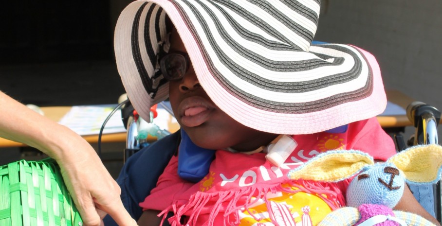 young girl with ventilator wearing summer hat